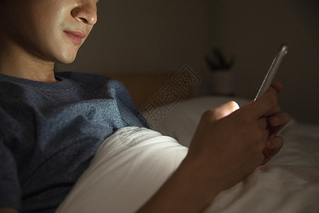 躺床上玩手机男子熬夜玩手机背景
