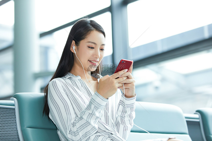 年轻女士机场候车玩手机图片