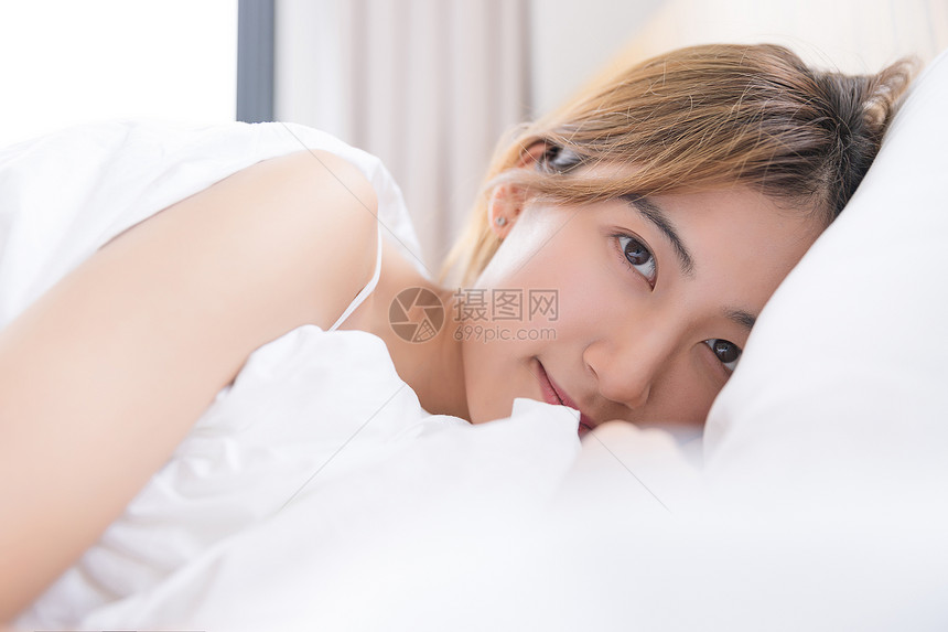 年轻女性在床上休息图片