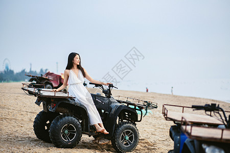 海边坐沙滩车的美女高清图片