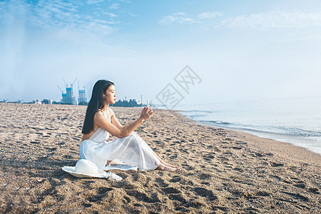 女人海边自拍海边玩手机听音乐的美女背景