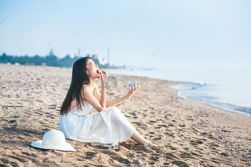 海边吃零食的女孩图片