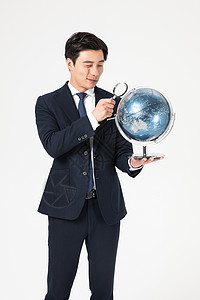 商务男性地球仪商务男青年用放大镜看地球仪背景