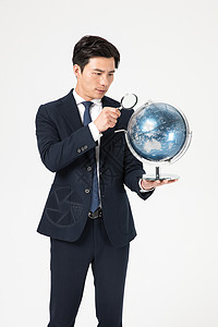 商务男性地球仪商务男青年用放大镜看地球仪背景