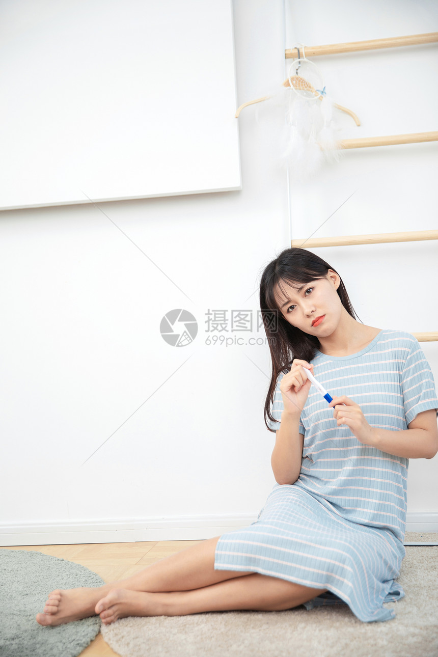 女生在卧室看到验孕结果很苦恼图片