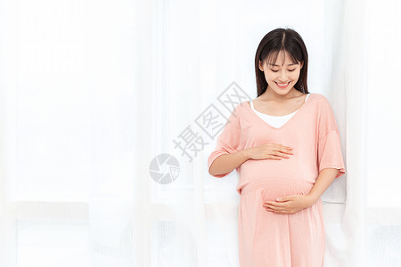 女人肚子一个孕妇在客厅站着抚摸肚子背景