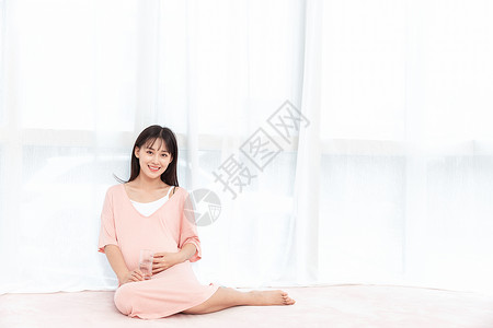 一个孕妇在客厅坐着抚摸肚子图片