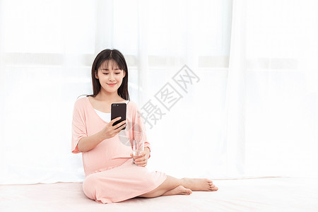 中国微信素材一个孕妇在客厅纱窗旁边使用手机背景