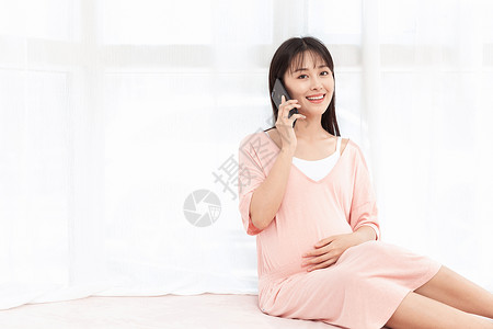 孕妇在客厅纱窗旁边使用手机打电话怀孕高清图片素材