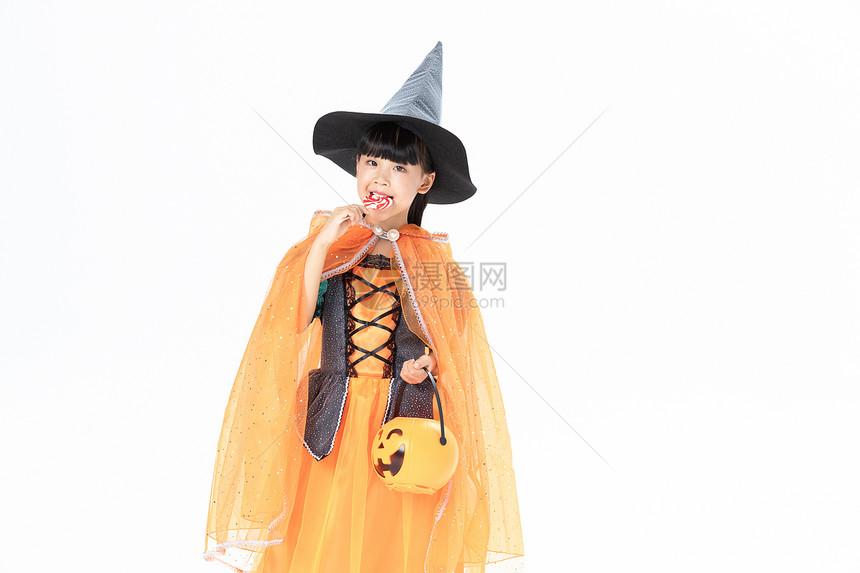 可爱小女孩万圣节女巫打扮拿着南瓜灯和棒棒糖图片