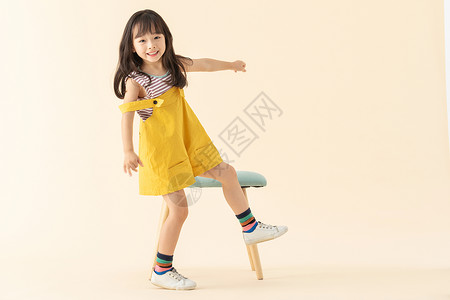 站着小女孩可爱小美女在站在椅子旁边背景
