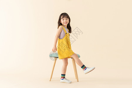 站着小女孩可爱小美女在站在椅子旁边背景