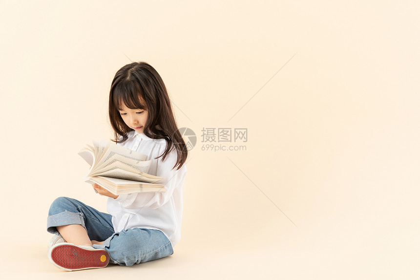 小女孩坐在地上看书