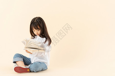 小女孩坐在地上看书高清图片