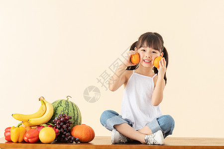 小女孩手拿橙子高清图片