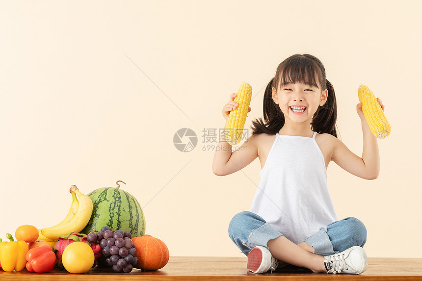 小女孩手拿玉米图片