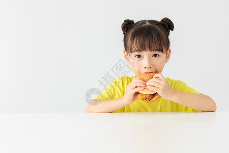 提着垃圾女孩小女孩开心的吃着汉堡包背景