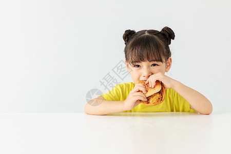 提着垃圾女孩小女孩大口的吃着汉堡包背景