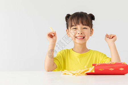 吃薯条女孩小女孩开心的吃着薯条背景