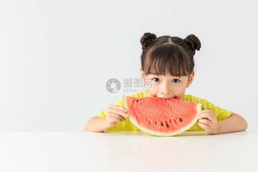 可爱小女孩在桌子上吃西瓜图片