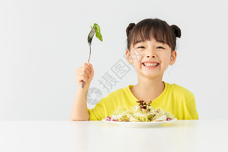 可爱早餐小女孩开心的吃着蔬菜沙拉背景