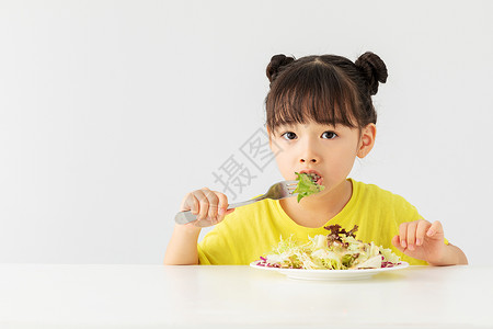 小女孩开心的吃着蔬菜沙拉图片