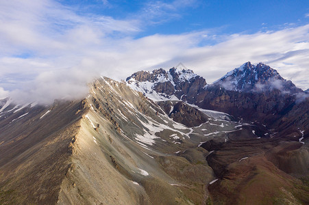 新疆山野雪山云雾航拍背景图片