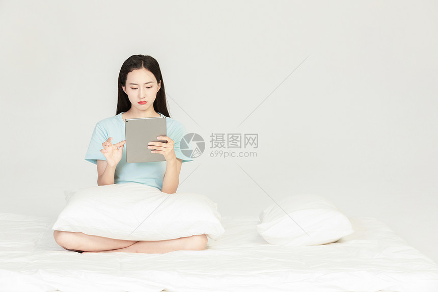 女性坐在床上看平板图片