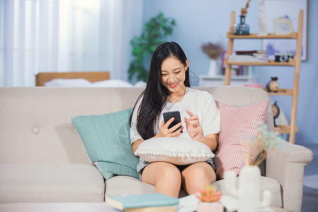 美女在客厅女性在沙发上娱乐背景