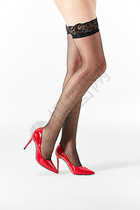 女性展示黑色丝袜和红色高跟鞋图片