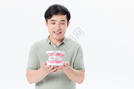 男性假牙展示中年男性拿着假牙背景