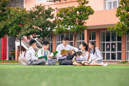 老师和学生坐在操场上讨论教育高清图片素材