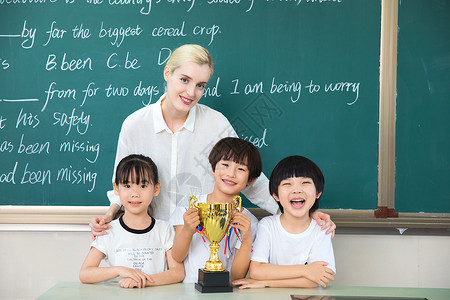 老师与儿童在教室与奖杯合影图片