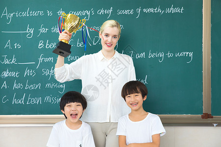 外国人在中国老师与儿童在教室与奖杯合影背景