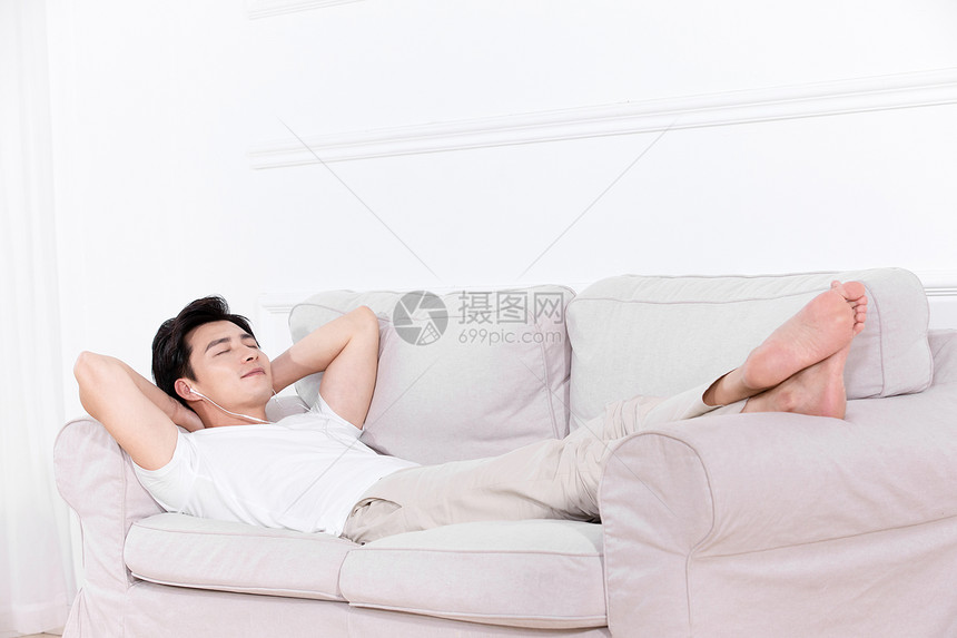男性躺在沙发上休息图片