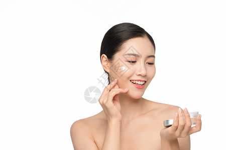 湿润乳液美女使用面部护肤品乳霜背景