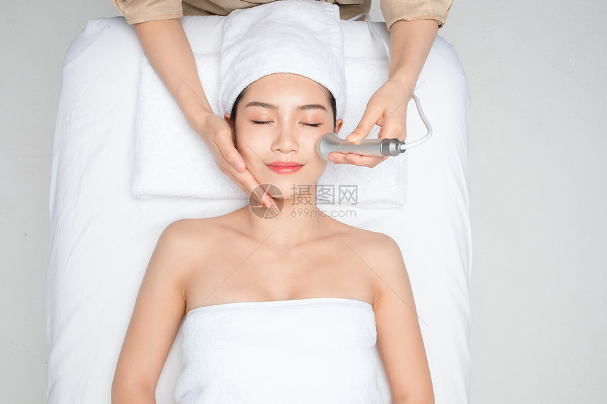 躺在床上做面部护理的女性图片