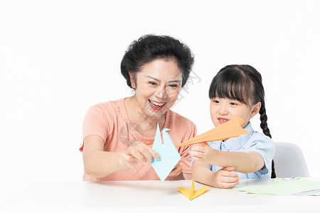 奶奶和孙女一起折纸飞机模特高清图片素材