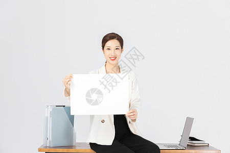 坐在办公桌前拿着白纸的商务女性高清图片