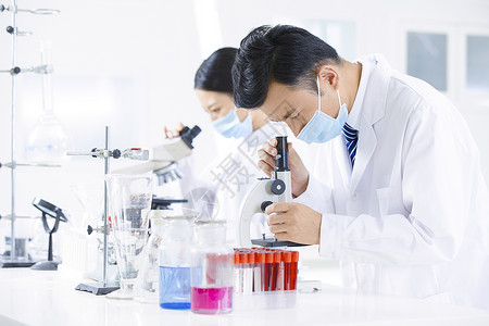 生物实验素材疫情下的医疗研究人员用显微镜观察背景