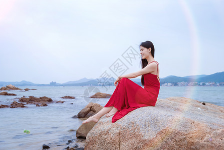 深圳较场尾海边礁石上的红衣少女萌妹子高清图片素材