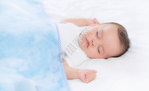 盖着毯子的婴儿在床上熟睡高清图片