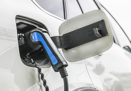 特斯拉充电桩正在充电的新能源汽车和充电枪特写背景