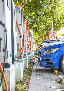 新能源汽车充电站充电桩和正在充电的汽车背景图片