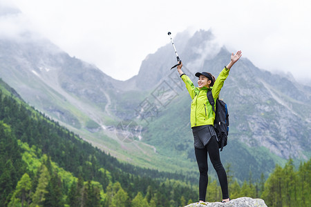 出户外登山的女生行户外登山拥抱自然的女生背景