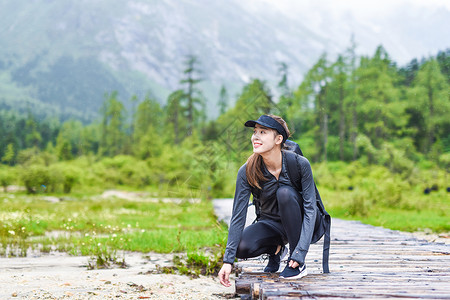 登山之旅旅途中劳累歇脚的女生背景