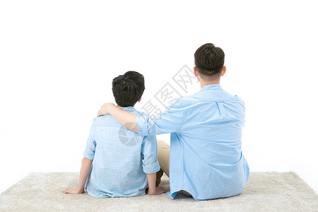 父子一起坐地毯上看远方背景图片