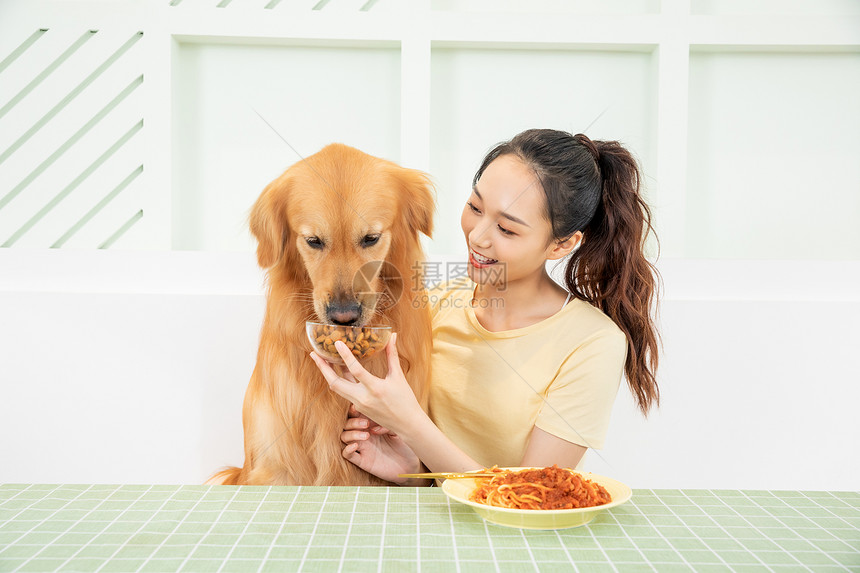 美女主人和宠物狗一起吃饭图片