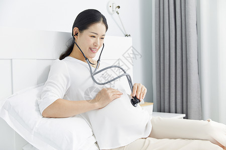 宝宝听孕妇用听诊器听宝宝胎动背景