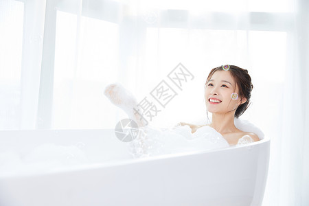在浴室美女躺在浴缸洗泡泡浴背景